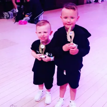 Two of the youngest pupils holding trophies at a ballroom competition